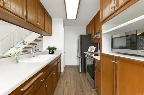 a kitchen with stainless steel appliances granite countertop a sink stove and refrigerator