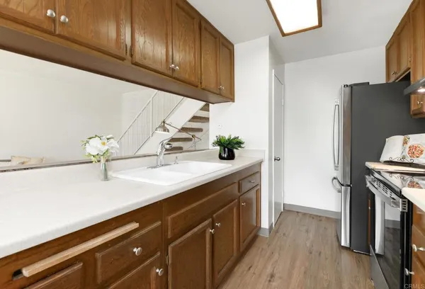 a kitchen with granite countertop a sink a stove and wooden floor