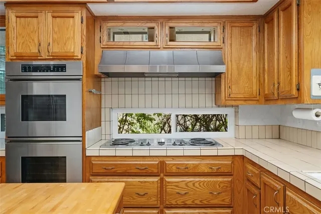 a dining hall with stainless steel appliances granite countertop a sink and a counter space