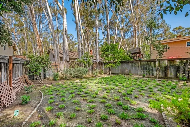 a view of backyard with table and chairs and wooden fence