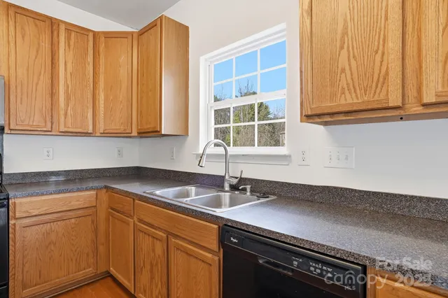 a kitchen with stainless steel appliances granite countertop a sink and a white cabinets