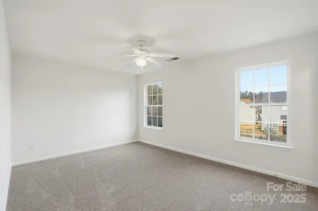 an empty room with a ceiling fan and a window