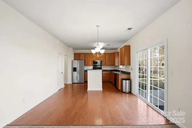 a kitchen with stainless steel appliances kitchen island wooden cabinets and a stove