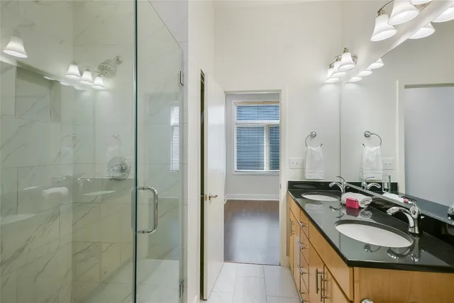 a bathroom with a double vanity sink a mirror and shower