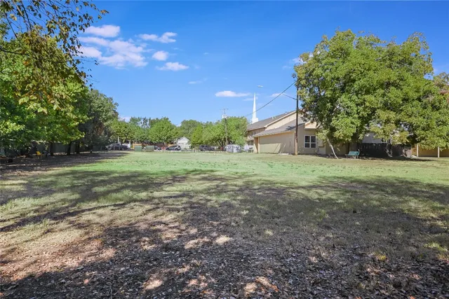 a view of a field with trees in the background