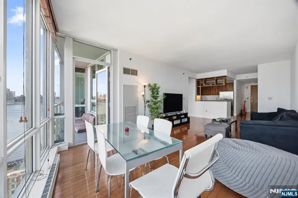 a living room with furniture a flat screen tv and a large window