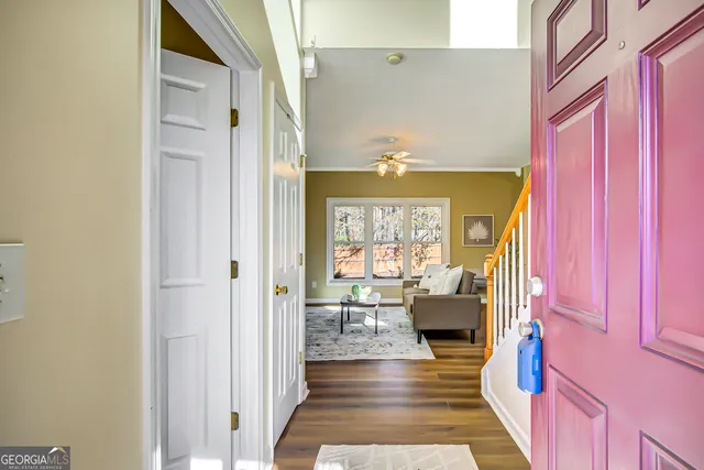 a hallway with a couch and chandelier next to a window
