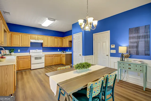 a kitchen with a table chairs sink and cabinets