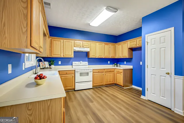 a kitchen with white cabinets and sink