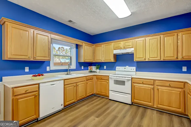 a kitchen with a stove sink and cabinets