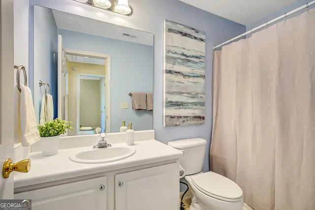 a bathroom with a sink a toilet and shower curtain
