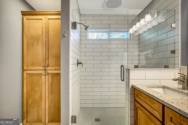 a bathroom with a granite countertop sink a shower and a mirror
