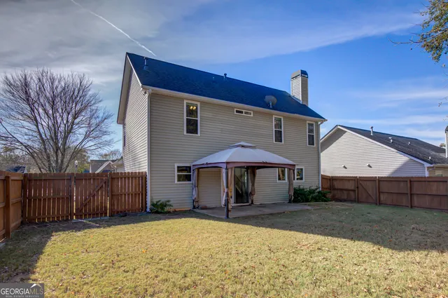 a front view of a house with yard and tree