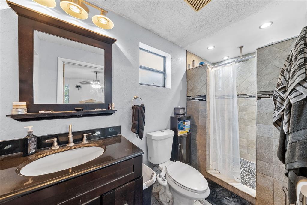 4245 Crestfield Avenue Holiday, FL 34691 - Photo 14 of 28 a bathroom with a sink a toilet a mirror and shower