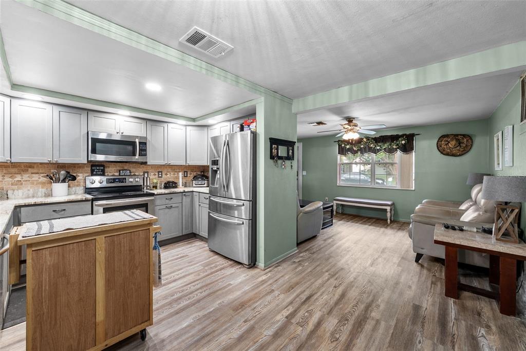 4245 Crestfield Avenue Holiday, FL 34691 - Photo 15 of 28 a kitchen with stainless steel appliances a refrigerator and a stove top oven