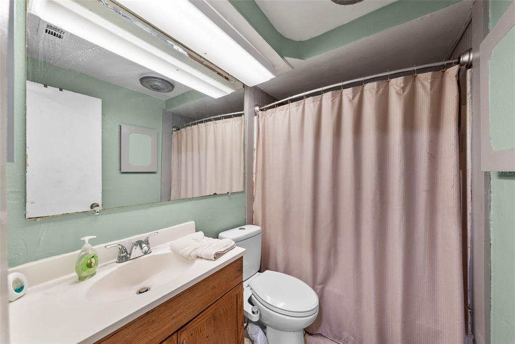 4245 Crestfield Avenue Holiday, FL 34691 - Photo 19 of 28 a bathroom with a sink a toilet and shower curtain