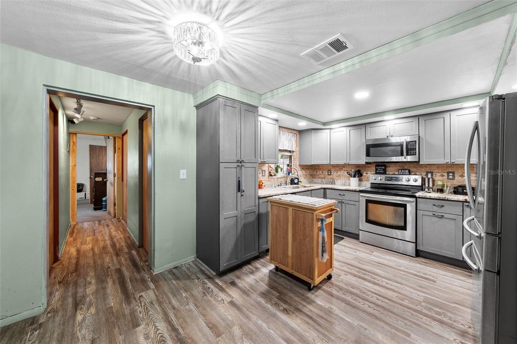 4245 Crestfield Avenue Holiday, FL 34691 - Photo 8 of 28 a kitchen with granite countertop a refrigerator and a stove top oven