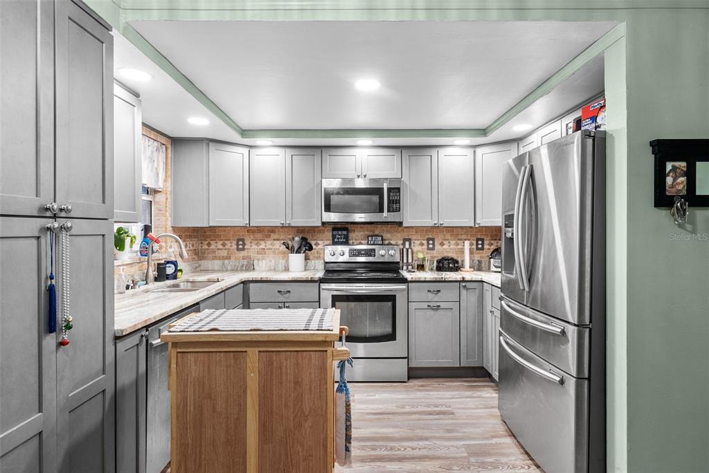 4245 Crestfield Avenue Holiday, FL 34691 - Photo 9 of 28 a kitchen with a sink stainless steel appliances and cabinets