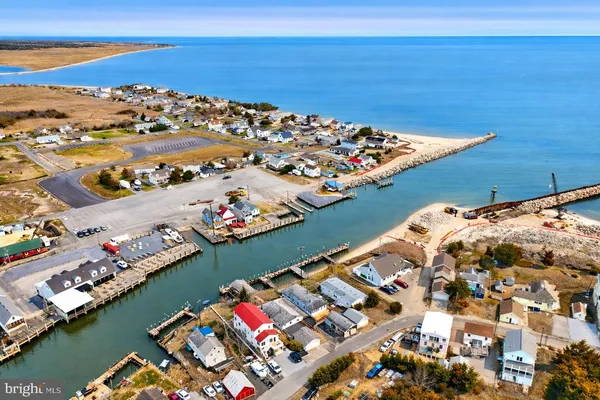 an aerial view of ocean and residential houses with outdoor space