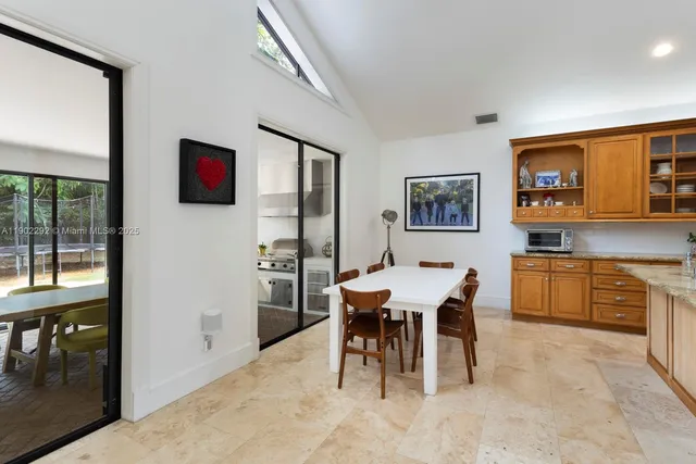 a view of a dining room with furniture and a kitchen