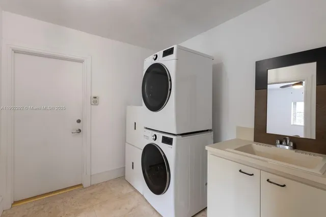 a utility room with sink dryer and washer