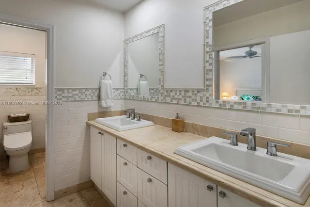 a bathroom with a sink double vanity and a toilet