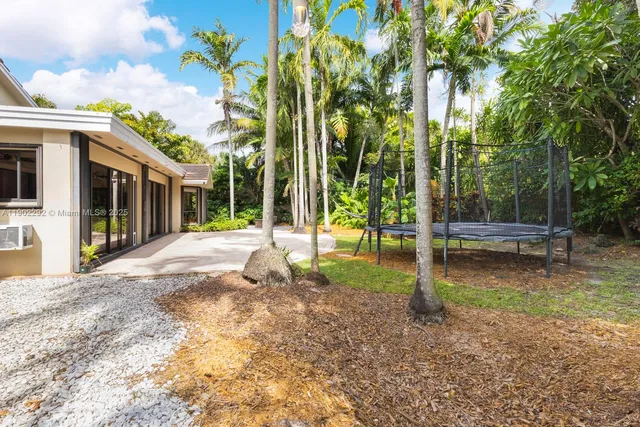 a view of a house with backyard and tree