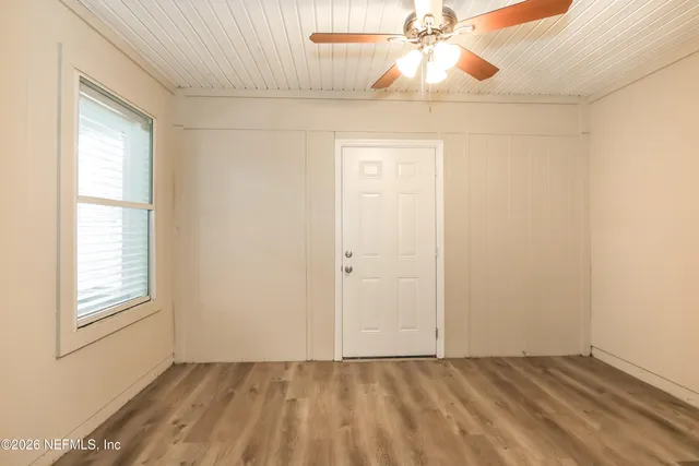 an empty room with windows and fan