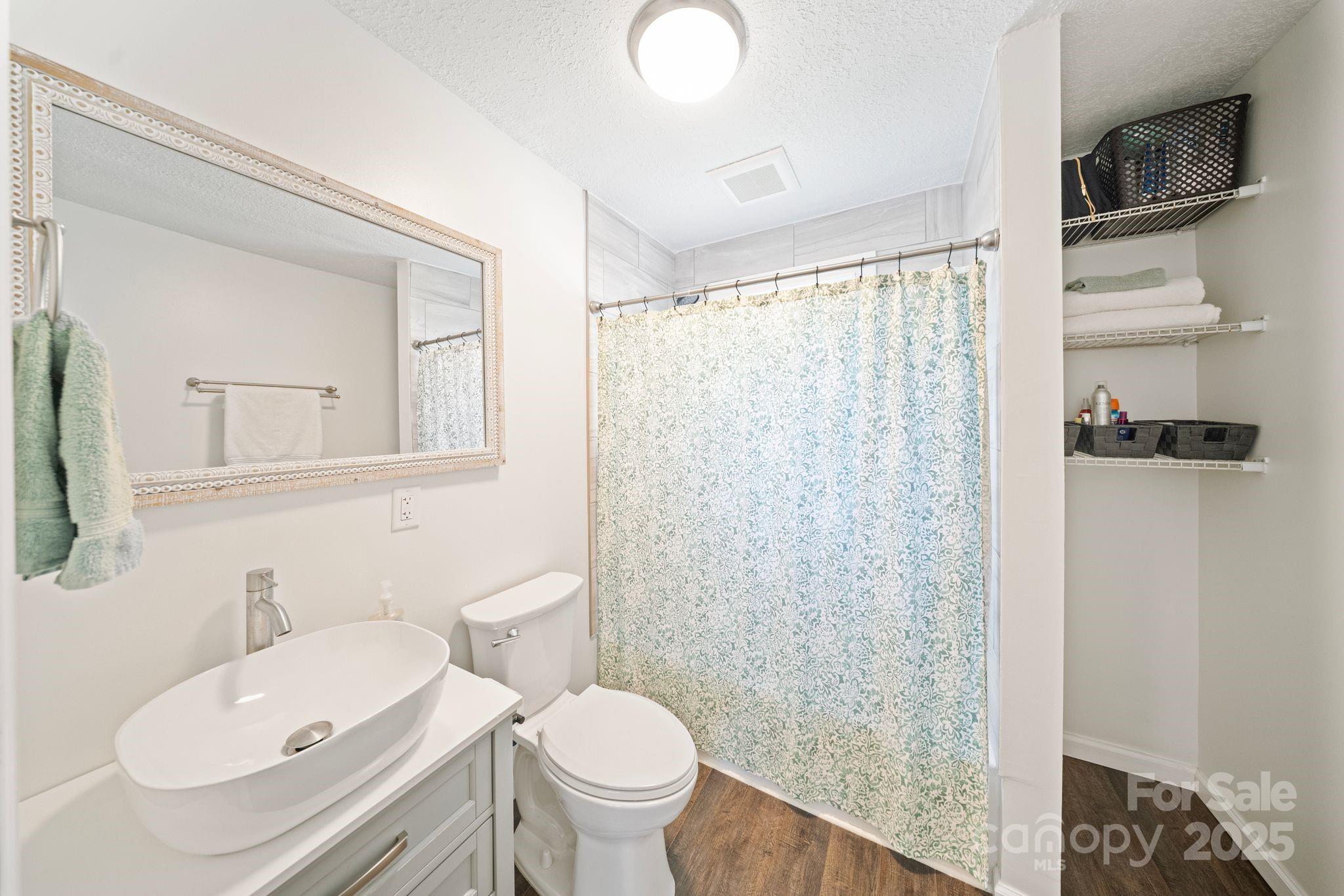 5703 Valley Field Road Southeast Hickory, NC 28602 - Photo 13 of 33 a bathroom with a sink a toilet and shower curtain