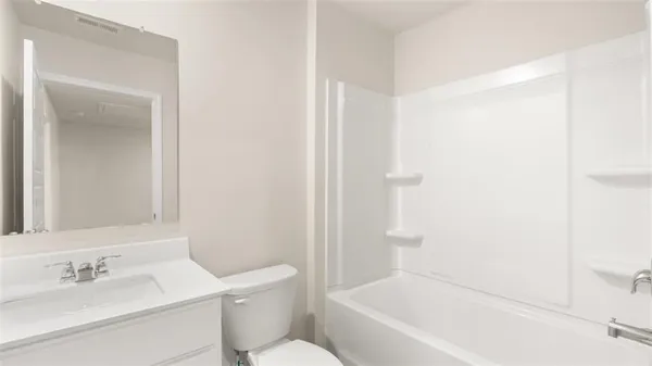 a bathroom with a bathtub shower sink vanity and toilet