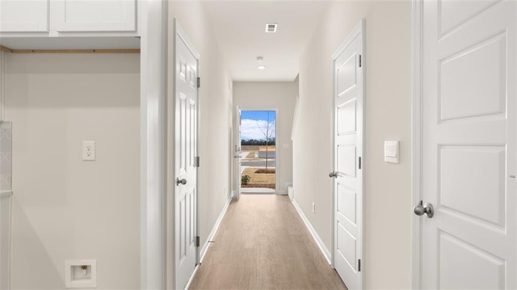 121 Kenmore Circle Perry, GA 31069 - Photo 6 of 28 a view of a hallway with wooden floor and a bathroom