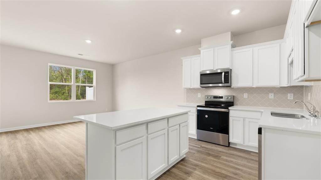 121 Kenmore Circle Perry, GA 31069 - Photo 7 of 28 a kitchen with stainless steel appliances granite countertop a stove a sink and a microwave