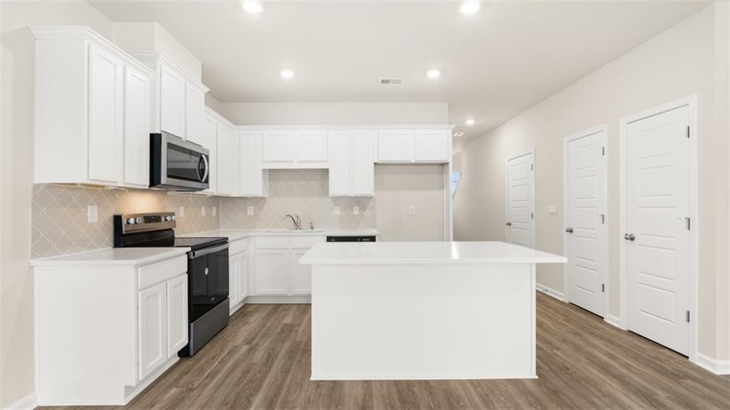 121 Kenmore Circle Perry, GA 31069 - Photo 9 of 28 a kitchen with a sink a stove top oven and white cabinets