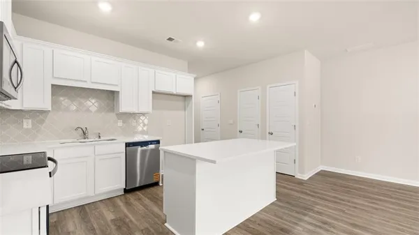 a kitchen with a sink a stove and cabinets