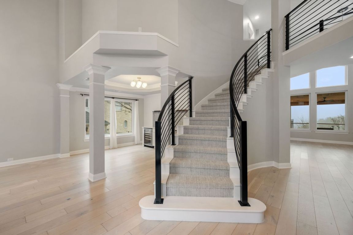 2137 Rivina Drive Austin, TX 78733 - Photo 11 of 39 Stairs with a high ceiling, hardwood / wood-style flooring, ornate columns, and beverage cooler