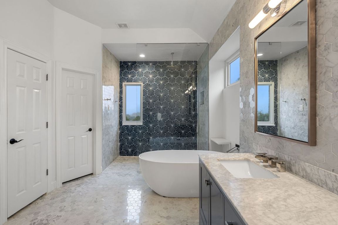 2137 Rivina Drive Austin, TX 78733 - Photo 15 of 39 Full bathroom featuring a walk in shower, vanity, tile walls, a freestanding tub, and recessed lighting