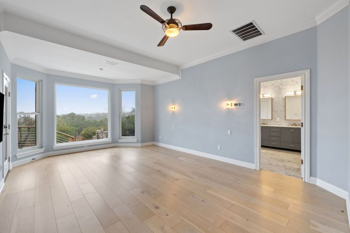 2137 Rivina Drive Austin, TX 78733 - Photo 18 of 39 Unfurnished bedroom with ornamental molding, ceiling fan, light wood finished floors, and connected bathroom