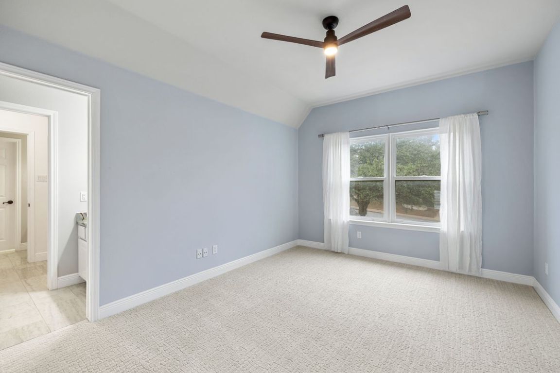 2137 Rivina Drive Austin, TX 78733 - Photo 28 of 39 Spare room with light carpet, ceiling fan, and vaulted ceiling