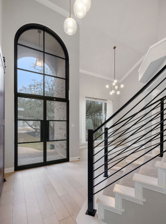 2137 Rivina Drive Austin, TX 78733 - Photo 10 of 39 Foyer entrance featuring light wood-type flooring, crown molding, a chandelier, and a high ceiling