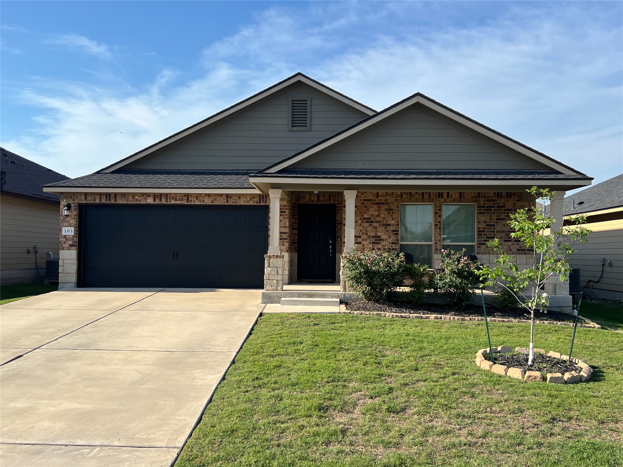 183 Beth Ann Loop Taylor, TX 76574 - Photo 1 of 1 View of front of house with driveway, a front yard, an attached garage, and brick siding
