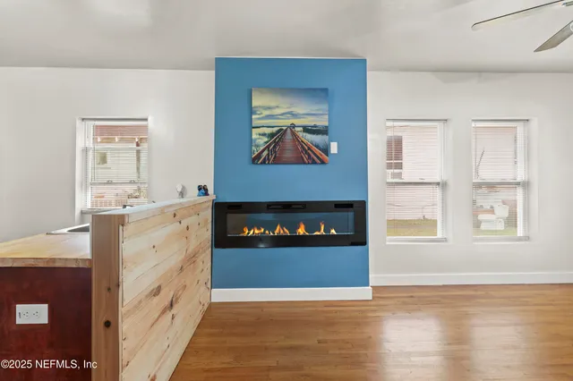 a view of a kitchen with a sink a fireplace and wooden floor