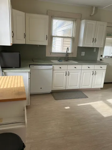 a kitchen with granite countertop white cabinets and sink