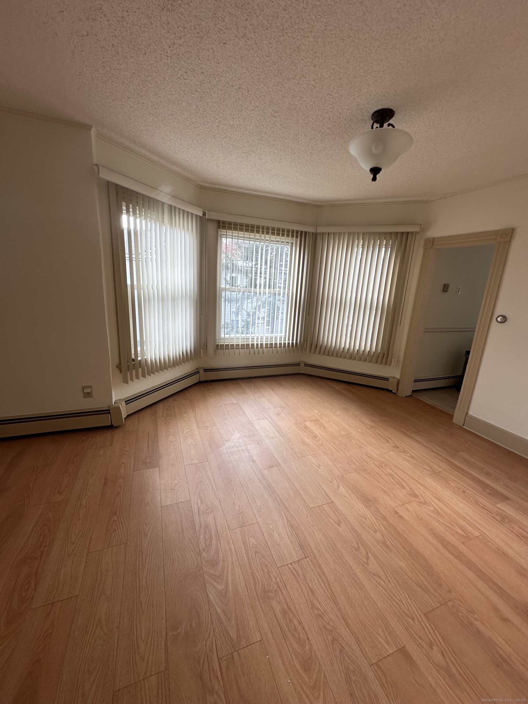 421 Main Street Wallingford, CT 06492 - Photo 5 of 27 an empty room with wooden floor and windows