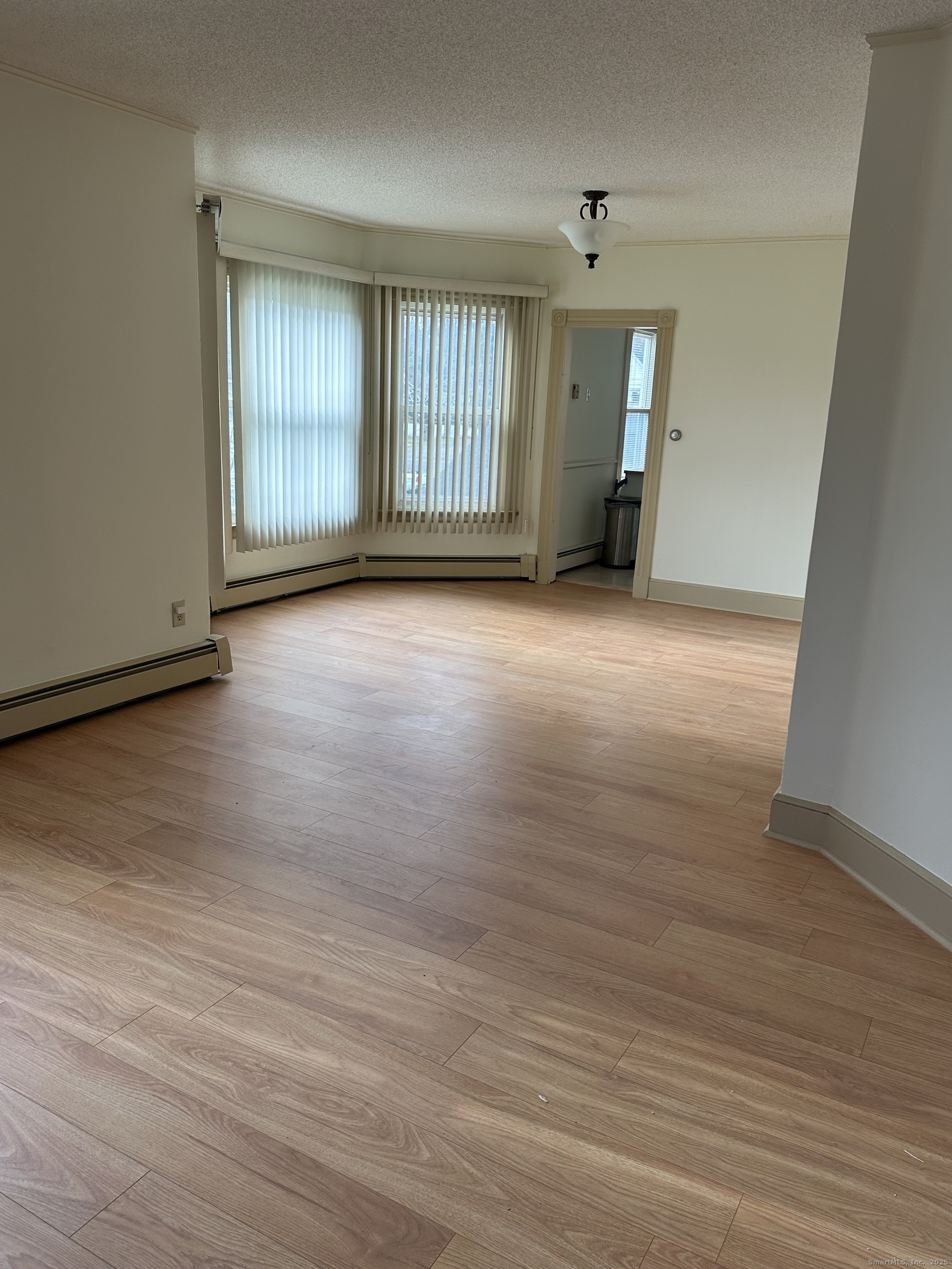 421 Main Street Wallingford, CT 06492 - Photo 7 of 27 an empty room with wooden floor and windows
