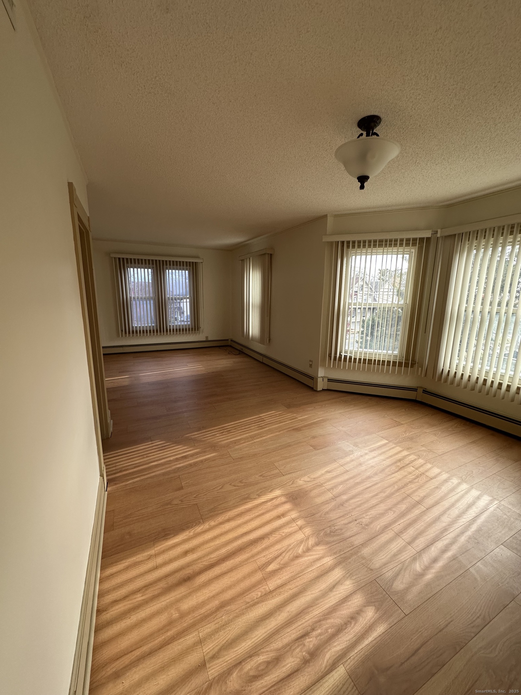 421 Main Street Wallingford, CT 06492 - Photo 8 of 27 an empty room with wooden floor and windows