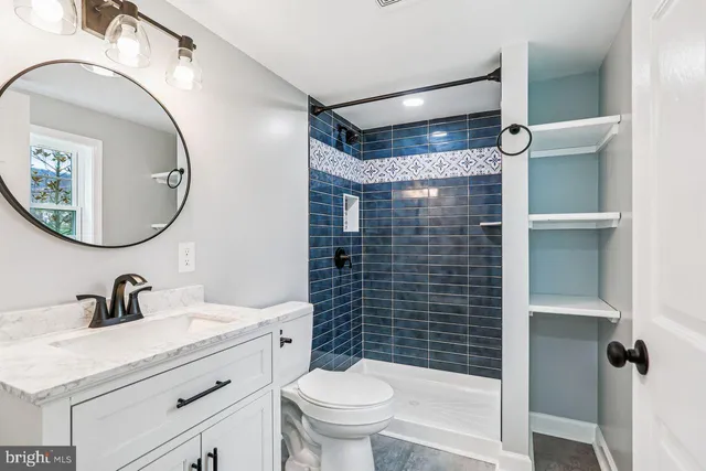 a bathroom with a sink a toilet a mirror and shower