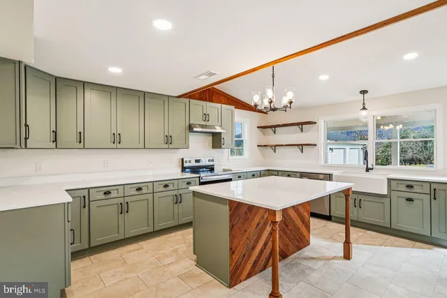 a kitchen with a sink a counter top space cabinets and stainless steel appliances