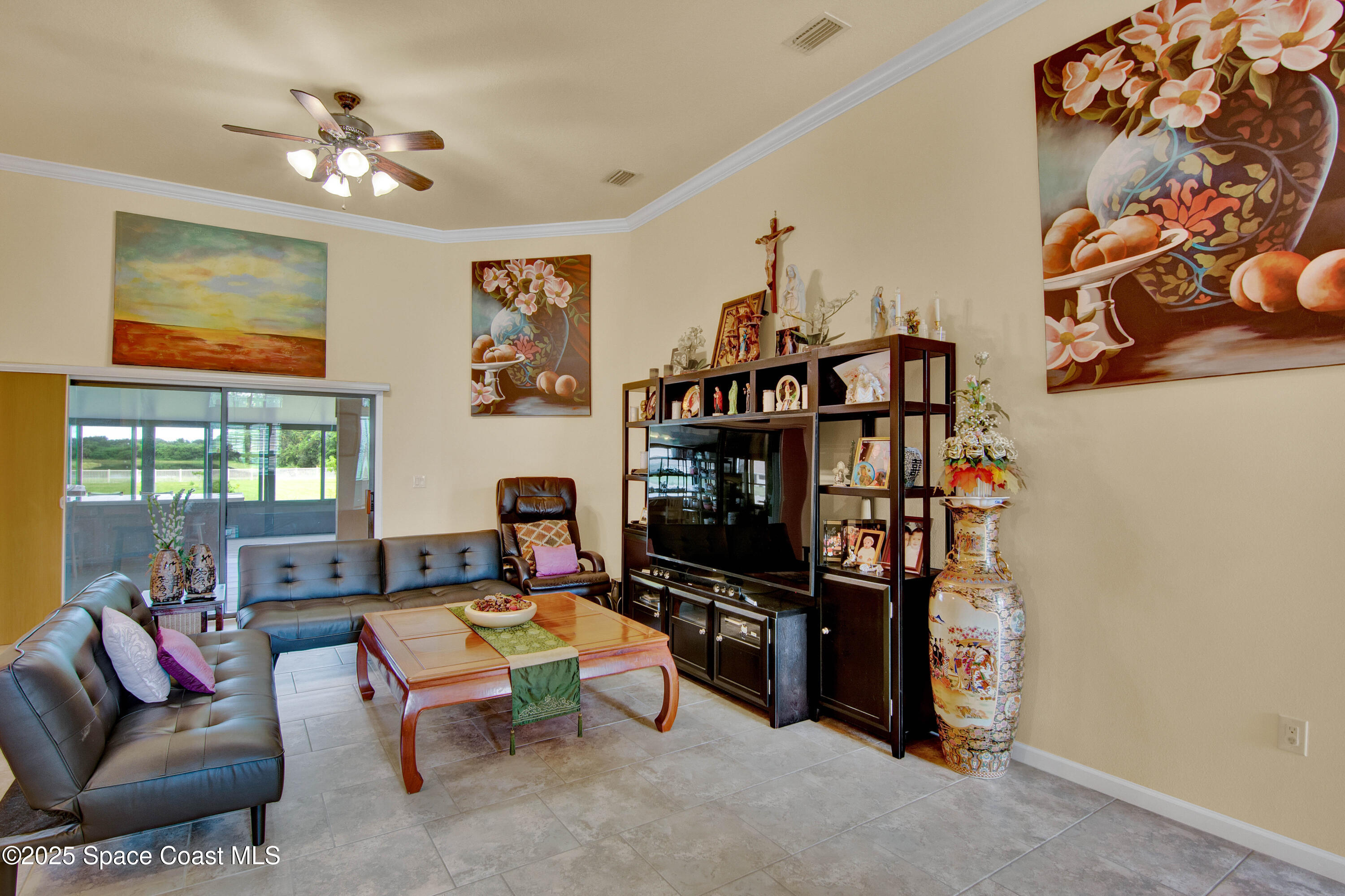 900 Hall Road Malabar, FL 32950 - Photo 13 of 28 a living room with furniture a flat screen tv and a bookshelf