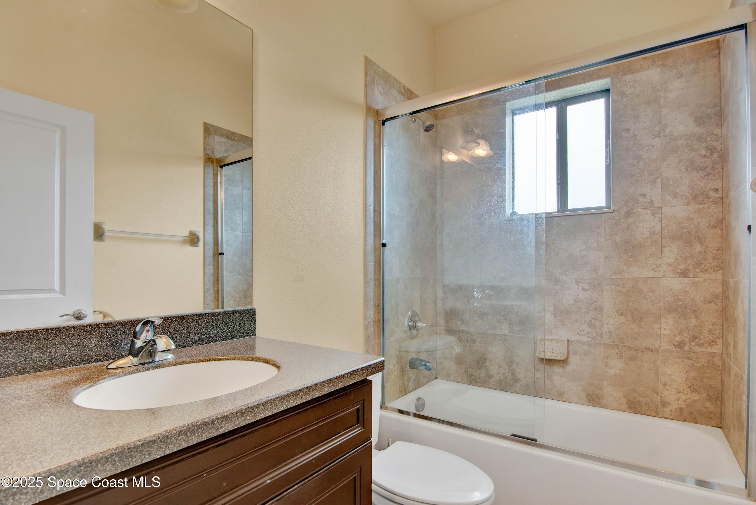 900 Hall Road Malabar, FL 32950 - Photo 18 of 28 a bathroom with a granite countertop sink toilet and shower
