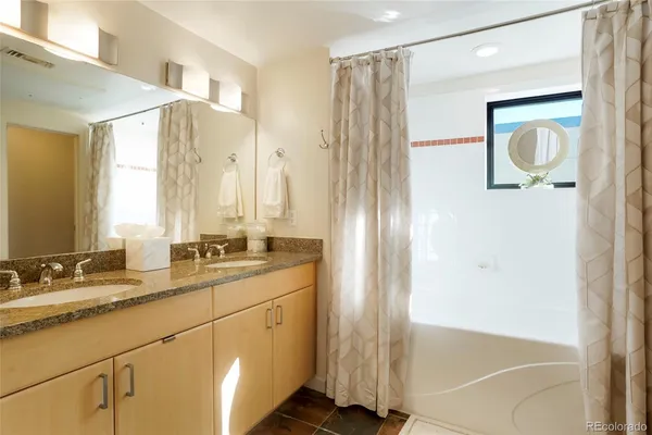 a bathroom with a double vanity sink mirror and shower